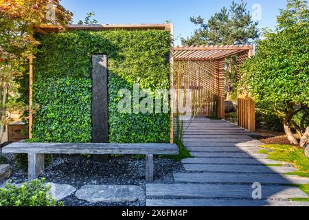 Chemin de conifères et d'ardoise avec paillis d'écorce et plantes indigènes dans le jardin japonais. Aménagement paysager et jardinage. Banque D'Images