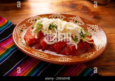 Entomatadas. Aussi connu sous le nom Enjitomatadas, un plat typique de la cuisine mexicaine préparé avec tortilla de maïs, sauce tomate et farci avec chicke râpé Banque D'Images