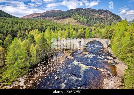 Vieux pont de Dee ou pont Invercauld près de la route principale de Braemar à la rivière Ballater et arbres au début du printemps Banque D'Images