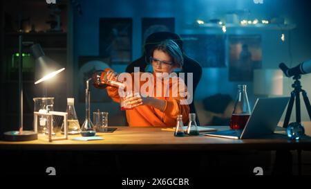 Smart Young Boy en lunettes de sécurité mélange des produits chimiques dans des béchers à la maison. Adolescent menant des expériences de Hobby en sciences éducatives, faisant des devoirs de biologie intéressants dans sa chambre. Banque D'Images