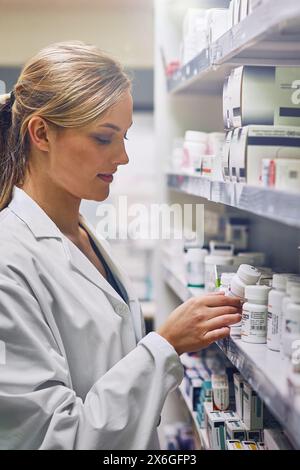 Pharmacien, choix et médecine sur étagère en magasin avec des médicaments, des pilules ou un inventaire de recherche. Pharmacie, femme et étiquette de lecture sur la boîte de suppléments ou magasin Banque D'Images