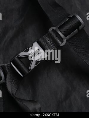 Attaches fastex en plastique noir sur les sangles d'un sac à dos en nylon noir gros plan Banque D'Images