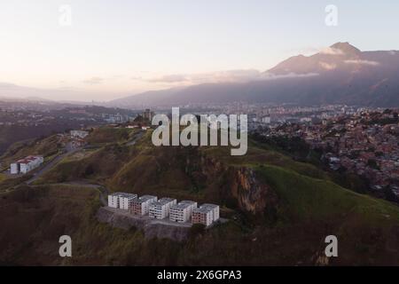 Vue aérienne de Caracas au coucher du soleil avec le quartier Petare, le plus grand bidonville du Venezuela et d'amérique latine, avec la montagne Avila dans l'arrière-pays Banque D'Images