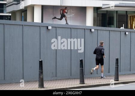 Coureur interagissant avec une figurine imprimée sur un bâtiment voisin le 7 mai 2024 à Londres, Royaume-Uni. Banque D'Images