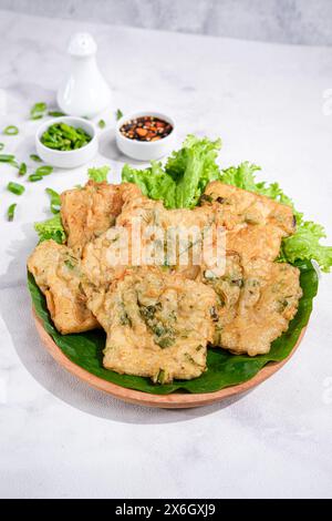 Tempeh frit ou Tempe Mendoan à base de fève de soja avec pâte à farine et oignon de printemps. Cuisine indonésienne Banque D'Images