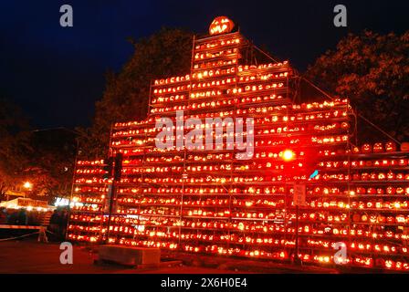 Un grand groupe de jack o’lanternes sculptées sont disposées sur des étagères et des échafaudages dans un parc lors d’un festival d’Halloween Banque D'Images