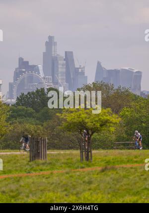 Richmond Park, Londres, Royaume-Uni. 15 mai 2024. Des vues lointaines sur les gratte-ciels du centre de Londres scintillant dans une brume chaude tandis que le temps se réchauffe à nouveau avec les cyclistes du Richmond Park profitant du soleil. Crédit : Malcolm Park/Alamy Banque D'Images