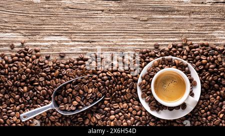 Vue de dessus panoramique de la tasse à espresso italienne avec grains de café torréfiés sur fond de bois brut. Espace vide Banque D'Images