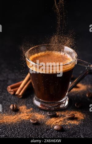 au premier plan, café expresso dans une tasse en verre aromatisée à la cannelle moulue Banque D'Images