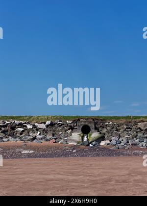 Un drain d'eau à Elliot Beach près d'Arbroath, permettant aux précipitations de s'écouler des champs et de Raised Beach Behind the Beach d'entrer dans la mer. Banque D'Images