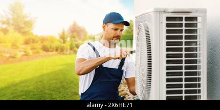 technicien travaillant sur la climatisation de maison ou l'unité extérieure de pompe à chaleur. Entretien, entretien et réparation de CVC. bannière avec espace de copie Banque D'Images