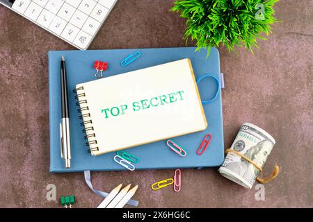 La phrase, Top secret, écrite sur une feuille vierge d'un cahier. Vue de dessus Banque D'Images