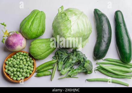 mise en page créative de légumes sains composés de laitue, concombres, brocolis, haricots verts, pois, navet, chou, chayote sur fond blanc, Banque D'Images