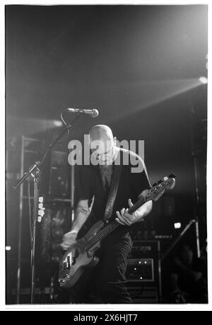 NICK OLIVERI, CLASSÉ R TOURNÉE, 2001 : Nick Oliveri du groupe de rock Queens of the Stone Age (QOTSA) lors de leur tournée Rated R Tour au Newport Centre à Newport, au pays de Galles, au Royaume-Uni, le 7 juin 2001. Photo : Rob Watkins. INFO : Queens of the Stone Age, un groupe de rock américain formé à Palm Desert, en Californie, en 1996, a redéfini le rock moderne avec ses riffs lourds et ses mélodies complexes. Des tubes comme « No One Knows » et « Go with the Flow » mettent en valeur leur son dynamique et leur approche innovante de la musique. Banque D'Images