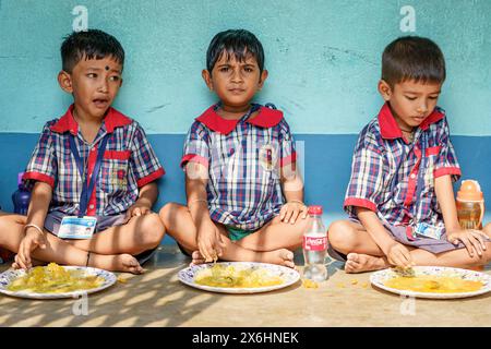 Kolkata, Inde - 20 octobre 2024 : enfants en uniforme déjeunant dans une école indienne. Concept de croissance, d'éducation, de nutrition et d'enfance Banque D'Images