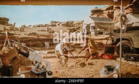 Site de fouilles archéologiques : deux grands archéologues travaillent sur le site d'excavation, nettoyant soigneusement avec des brosses et des outils nouvellement découverts artefacts culturels de civilisation ancienne, restes fossiles Banque D'Images