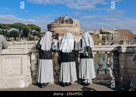 Les religieuses sur le Ponte Vittorio Emanuele II regardent Rome et Castel Angelo Banque D'Images