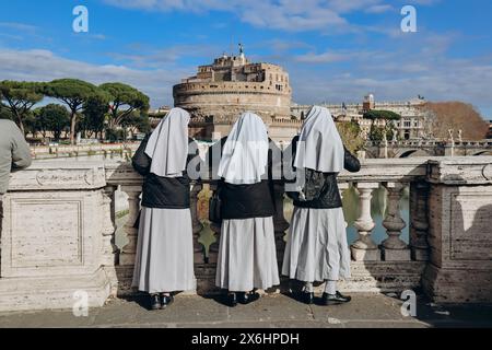 Les religieuses sur le Ponte Vittorio Emanuele II regardent Rome et Castel Angelo Banque D'Images