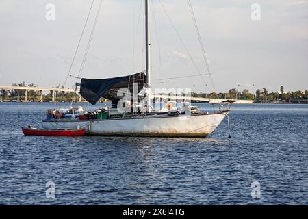 Vieux voilier, ancré, pont et cockpit rempli de choses, canoë attaché le long, ICW, Atlantic Intracoastal Waterway, printemps, Floride Banque D'Images