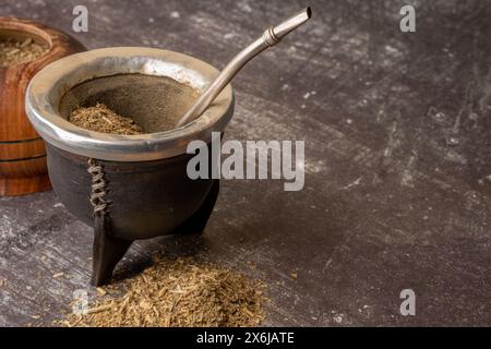 Boisson infusée saine, thé Yerba Mate classique dans une gourde avec bombilla et herbe sur un fond gris clair. Banque D'Images