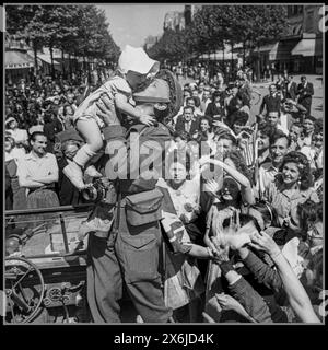 1944 Paris WW2 libération août 1944 Un photographe de l'armée britannique embrasse un bébé entouré de foules parisiennes extatiques Paris France Banque D'Images