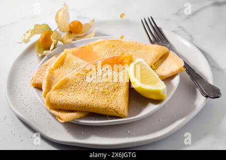 Crêpes sans gluten et sans produits laitiers avec sucre glace, citron et sirop d'orange sanguine Banque D'Images