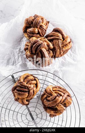 Nœuds de caramel-cannelle fraîchement cuits sur une grille à gâteau Banque D'Images