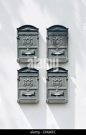 Boîtes aux lettres italiennes vintage typiques en gris, sur un mur blanc Banque D'Images