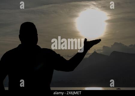 L'image capture un moment poignant alors qu'un homme de 30 ans se dresse devant un coucher de soleil à couper le souffle. Banque D'Images