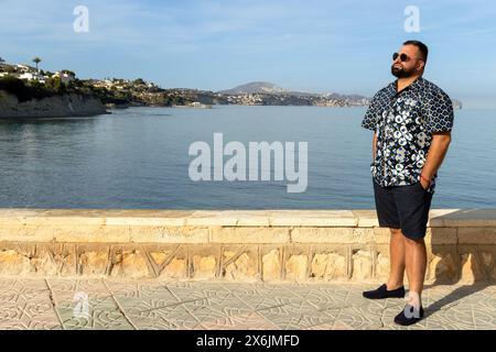 Ce portrait capture un homme de 30 ans dans un moment de réflexion paisible au bord de la mer. Banque D'Images