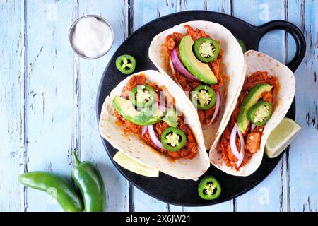 Tacos végétaliens Jack fruit. Scène de table vue de dessus sur un fond de bois bleu. Substitut de viande de porc effilochée à base de plantes et de nourriture saine. Banque D'Images