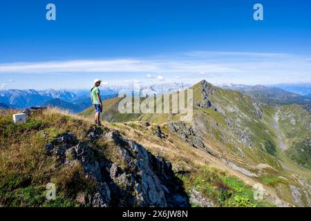 Alpiniste sur une crête de montagne herbeuse, panorama de montagne, vue sur la crête de montagne et le sommet Hochspitz ou Monte Vacomun, Carnic High Trail, Carnic Banque D'Images