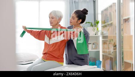 Femme âgée faisant un exercice avec une bande de résistance pour la physiothérapie avec une infirmière en clinique. Fitness, soins de santé et patiente âgée faire Banque D'Images