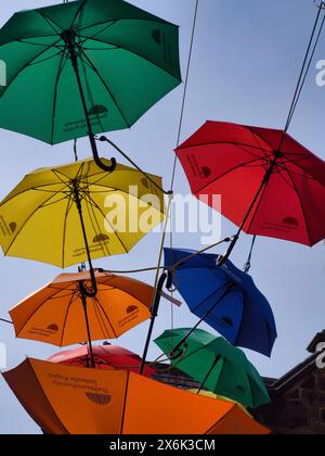 Parapluies colorés lumineux suspendus dans le ciel Banque D'Images