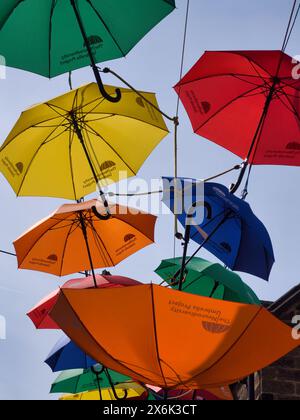 Parapluies colorés lumineux suspendus dans le ciel Banque D'Images