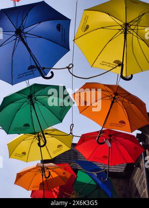 Parapluies colorés lumineux suspendus dans le ciel Banque D'Images