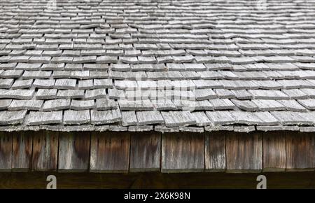 Vieux toit de maison en bois fait de planches grises rugueuses, photo de fond avec mise au point sélective Banque D'Images