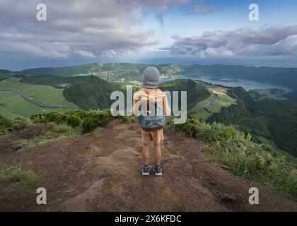 Petit garçon avec son ours en peluche au point de vue Miradouro da Boca do Inferno surplombant les lacs volcaniques de Sete Cidades sur l'île de Sao Migue Banque D'Images