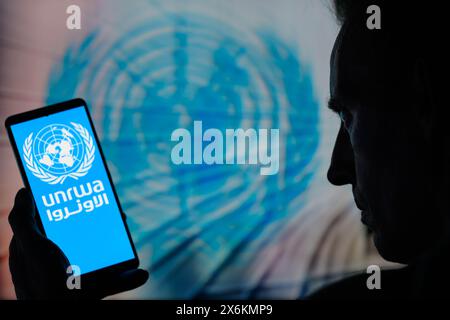 Bruxelles, Belgique. 15 mai 2024. Le logo de l'UNRWA est affiché sur un téléphone intelligent avec l'icône ONU visible en arrière-plan sur cette photo. Prise à Bruxelles, Belgique. Le 15 mai 2024. (Jonathan Raa/Sipa USA) *** strictement à des fins éditoriales *** crédit : Sipa USA/Alamy Live News Banque D'Images