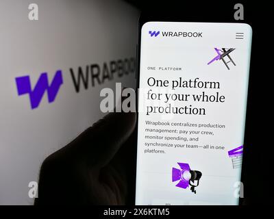 Personne tenant le téléphone portable avec la page Web de la société américaine de logiciels TakeOne Network Corp. (Wrapbook) devant le logo. Concentrez-vous sur le centre de l'écran du téléphone. Banque D'Images