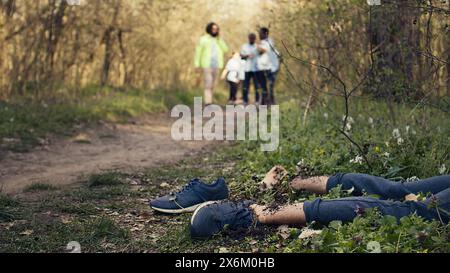 Groupe de sauveteurs trouvant une victime assassinée pieds nus dans la forêt, effrayé les gens appelant la police. Mystérieuse horreur homicide involontaire dans les bois, des civils ont trouvé un cadavre, un sombre meurtre. Caméra B. Banque D'Images