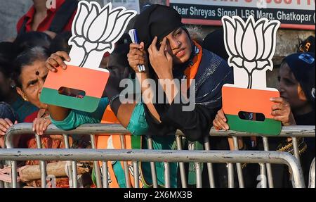 Mumbai, Inde. 15 mai 2024. Des partisans du Bharatiya Janata Party (BJP) sont vus tenant une fleur découpée dans du Lotus (symbole du BJP) avant le Road show à Mumbai. Le premier ministre indien Narendra Modi a organisé une tournée à Ghatkopar (quartier de la banlieue nord-est) à Mumbai pour canaliser le soutien aux candidats du Bharatiya Janata Party (BJP) aux élections de Lok Sabha alors que la ville ira voter le 20 mai 2024. Crédit : SOPA images Limited/Alamy Live News Banque D'Images