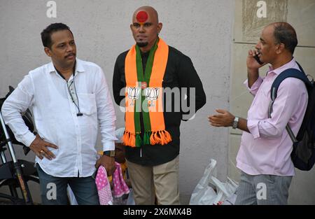 Mumbai, Inde. 15 mai 2024. Des partisans du parti Bharatiya Janata (BJP) sont vus debout dans la rue avant le défilé à Mumbai. Le premier ministre indien Narendra Modi a organisé une tournée à Ghatkopar (quartier de la banlieue nord-est) à Mumbai pour canaliser le soutien aux candidats du Bharatiya Janata Party (BJP) aux élections de Lok Sabha alors que la ville ira voter le 20 mai 2024. Crédit : SOPA images Limited/Alamy Live News Banque D'Images