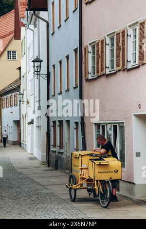 Fussen, Allemagne - 14 août 2023 : le facteur livre le courrier dans les rues de Füssen Banque D'Images