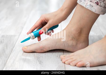 femme ponçant ses ongles d'orteils avec une ponceuse. mycose des ongles. maladie de l'ongle de pied. femme prenant soin des ongles des orteils. ongle jaune. meuleuse d'ongles électrique. entretien f Banque D'Images