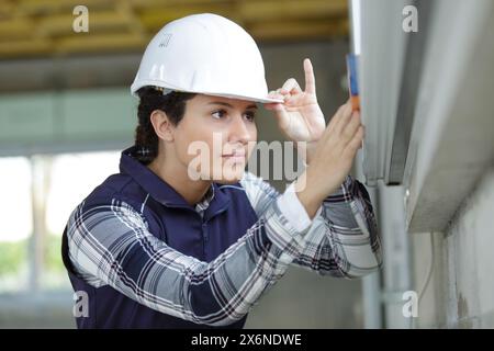 femme avec outil de mesure de niveau sur le chantier de construction Banque D'Images