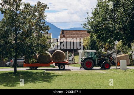 Barwies, Autriche - 15 août 2023 : un tracteur transporte des bottes de foin dans le village autrichien de Barwies Banque D'Images