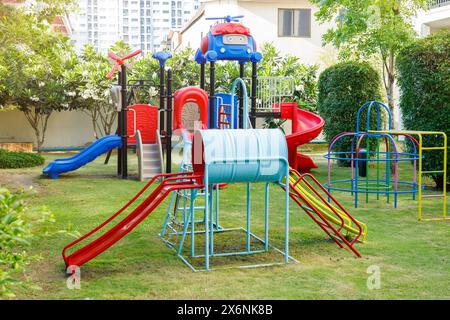 terrain de jeu amusant coloré machine excitante, petits enfants aire de jeux pour enfants dans l'herbe verte de cour déposée dans la ville Banque D'Images