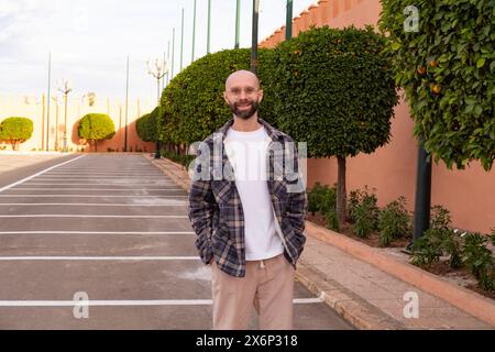 Touriste masculin au Maroc à côté de l'oranger dans le jardin public, immersion culturelle, patrimoine agricole, simples plaisirs voyage Banque D'Images