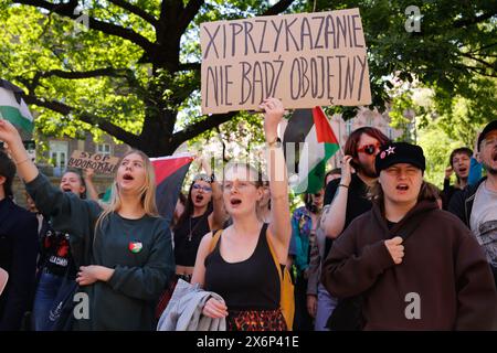 Des étudiants chantent des slogans pro-palestiniens et tiennent des drapeaux et des banderoles palestiniens lors de la première manifestation organisée en Pologne par des étudiants et des universitaires contre l'attaque israélienne sur la bande de Gaza devant le Collegium Novum, le bureau du doyen de l'Université Jagellonian à Cracovie, en Pologne, le 15 mai 2024. Banque D'Images